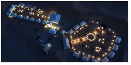 The camp lit up at night in the Merzouga dunes