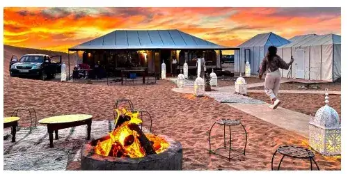 Dinner tables set at the camp at sunset