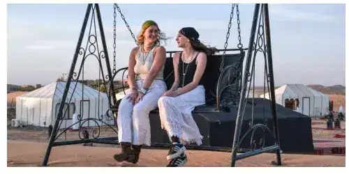 Guests on the swing at the edge of the Merzouga Glamping camp